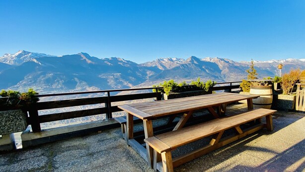 A wooden picnic table with benches, set against a backdrop of snow-capped mountains and clear blue sky. - Fontanettaz V 007 - MOUNTAIN apartment 8 pers (Veysonnaz)