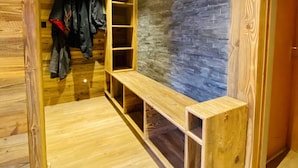A wooden interior with a bench, shelves, and hanging clothes. - Fontanettaz V 007 - MOUNTAIN apartment 8 pers (Veysonnaz)