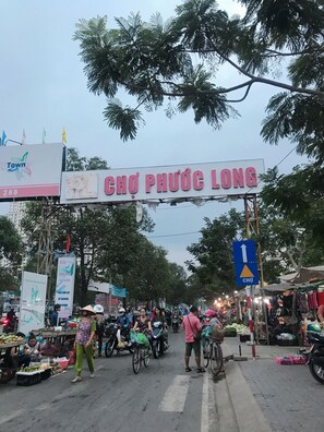 Ein belebter Markt mit einem gut sichtbaren Schild mit der Aufschrift "CHÔ PHƯƠC LÔNG".