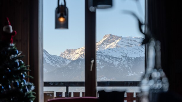 A window with a view of snow-covered mountains.