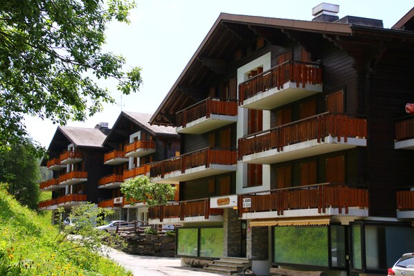 A multi-story hotel with balconies, a stone facade, and a sign indicating it is a hotel.