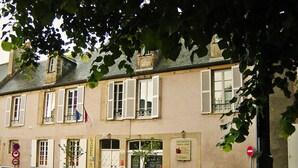 A building with multiple windows, some with shutters, and a sign that reads "CHAMBRES DHOTES". - Logis Les Remparts (Bayeux)