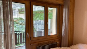 Ein Schlafzimmer mit einem hölzernen Kopfteil, einem Heizkörper und einem Bett mit einer gesteppten Bettdecke.