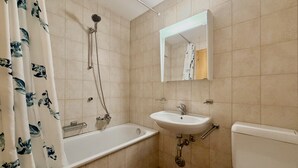 Un baño con bañera, lavamanos e inodoro.
