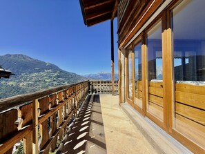 Un balcon en bois avec vue sur les montagnes.