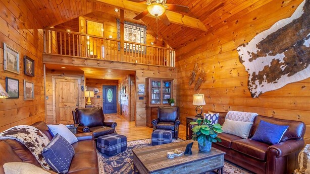 A spacious log cabin interior with a high ceiling, a balcony, leather furniture, and a rustic decor. - Mountain Lodge Near Downtown (Boone)
