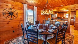 A wooden interior with a dining table set for six, surrounded by chairs. - Mountain Lodge Near Downtown (Boone)