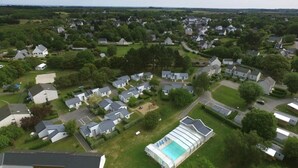 Vista aérea de una zona residencial con casas, piscina y áreas verdes.