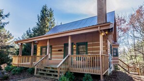 A log cabin with a porch, a chimney, and a metal roof. - Quaint Log Cabin in Great Location (Banner Elk)