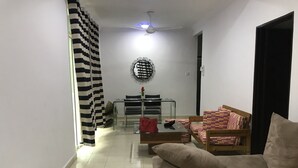 A living room with a sofa, a coffee table, and a dining area with chairs and a table.