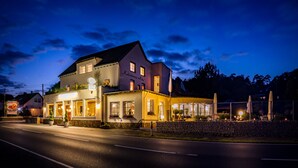 A two-story building with a sign reading "Kalenbornner Hof" and a covered outdoor seating area. - Hotel Kalenborner Hoehe (Kalenborn)