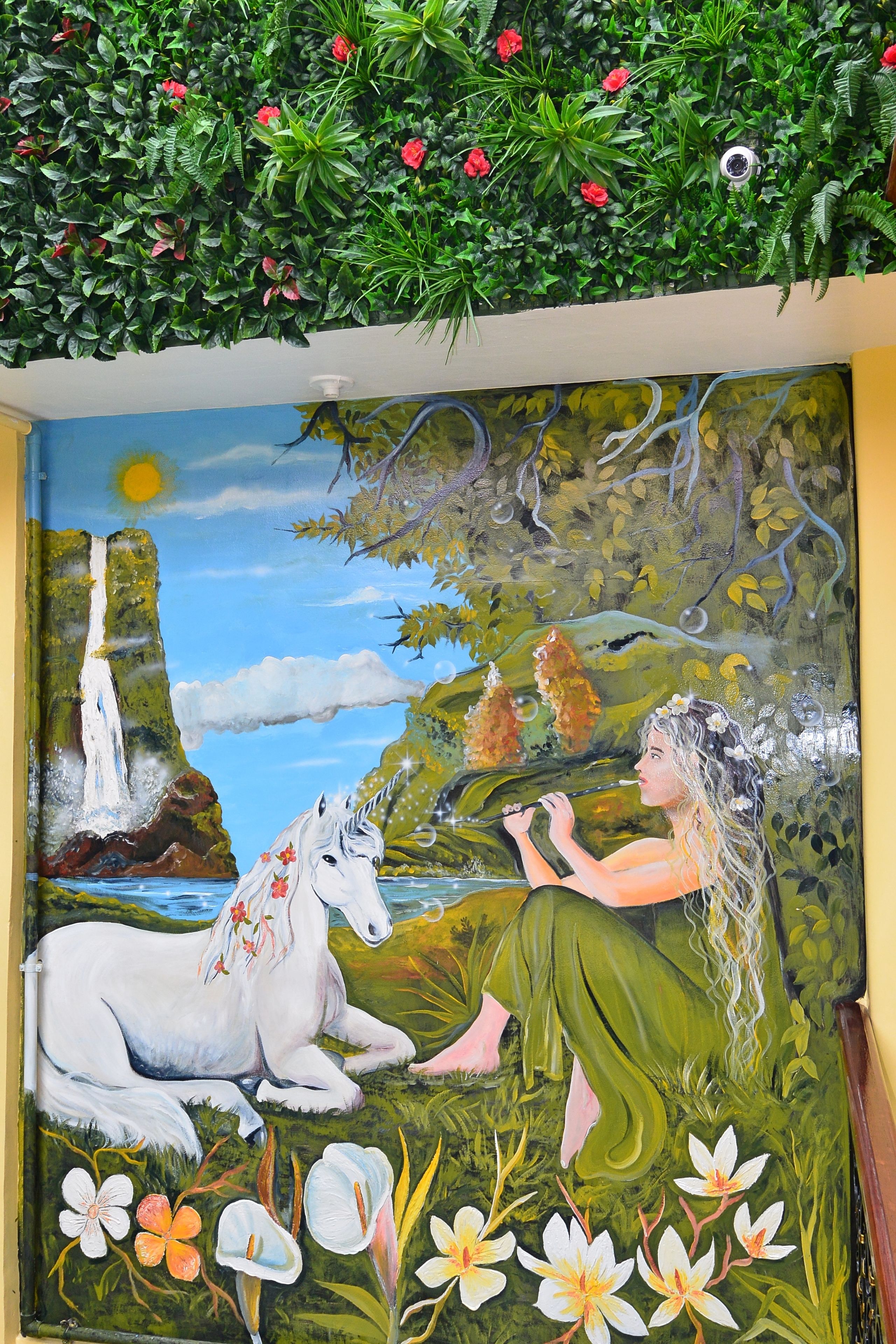 A mural with a waterfall, a unicorn, and a fairy.