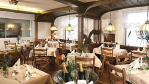 A restaurant with multiple tables, each set with white tablecloths, candles, and a centerpiece of flowers and champagne bottles. - Hotel Pohl zum Rosenberg (Kinheim)