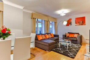 A modern living room with a sofa, armchairs, and a coffee table.