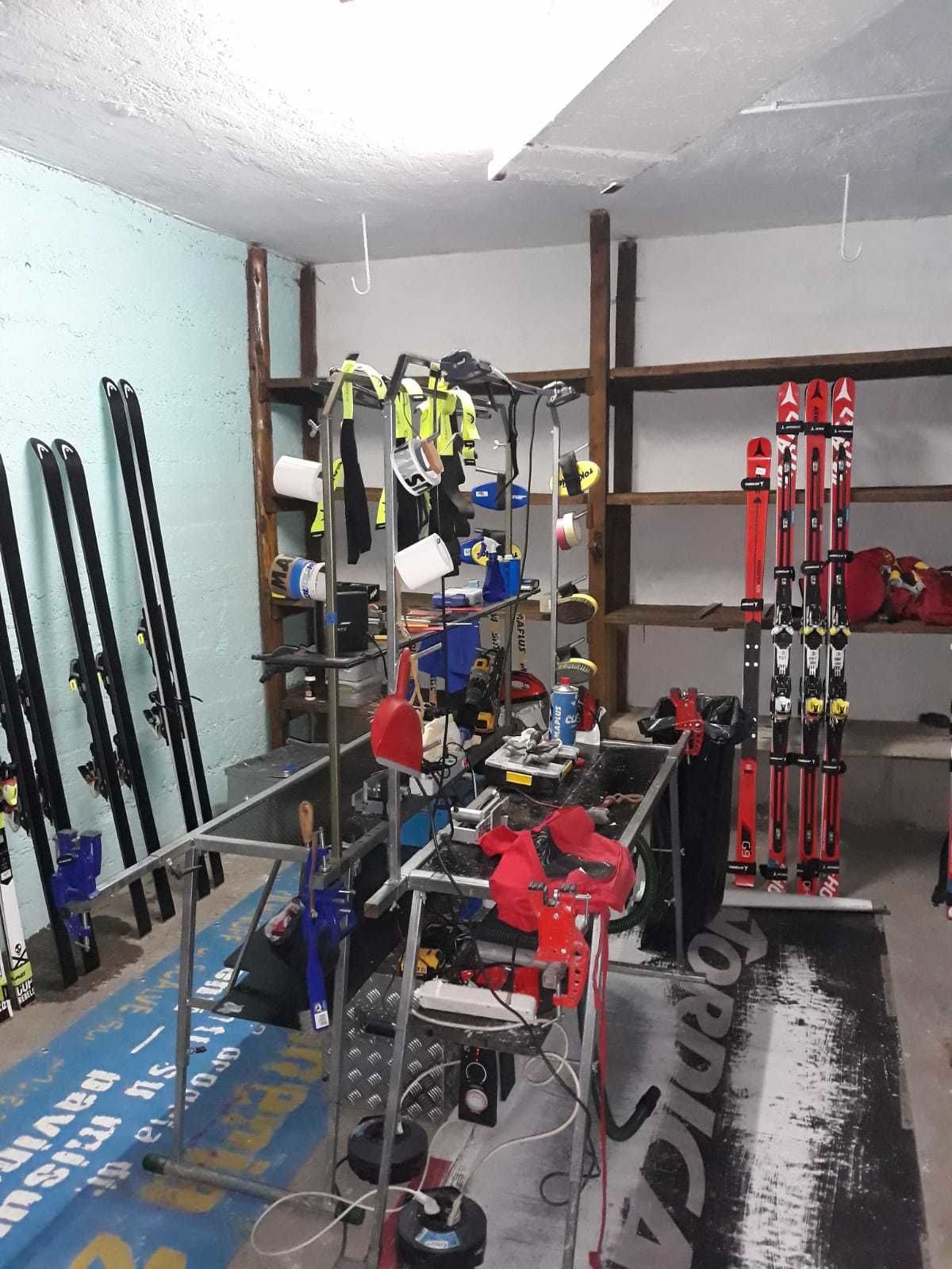 A ski storage area with skis, ski poles, and other equipment.