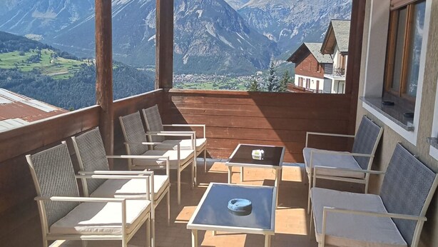 Un balcon avec coin salon extérieur et vue sur la montagne.