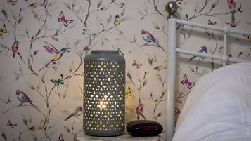 Une lampe décorée d’un motif d’oiseau, placée devant un mur.