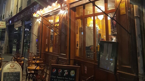 A hotel with a neon sign, outdoor seating, and a menu board. - Hôtel Linxa (Tours)