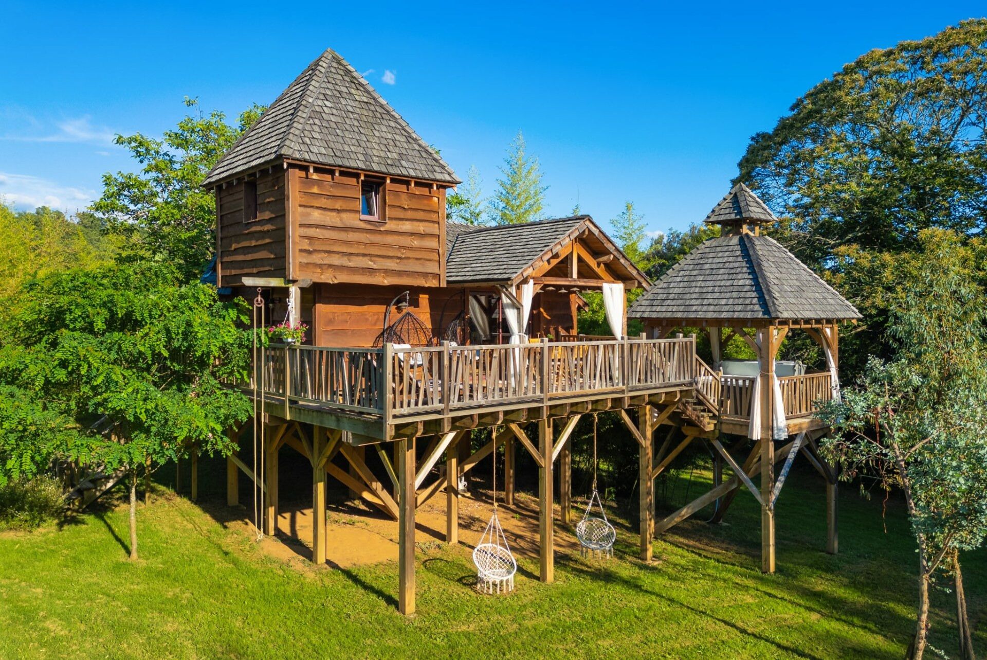 A wooden cabin with a deck and a gazebo.
