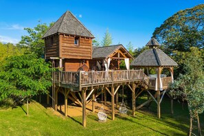 Une cabane en bois avec une terrasse et un belvédère.