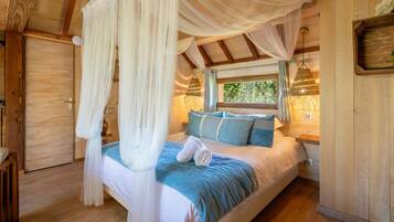 A bedroom with a canopy bed, wooden walls, and a window with a view of greenery.