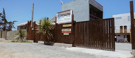 Un edificio moderno con un cartello che indica 'Pichilemu Apartment Hotel'.