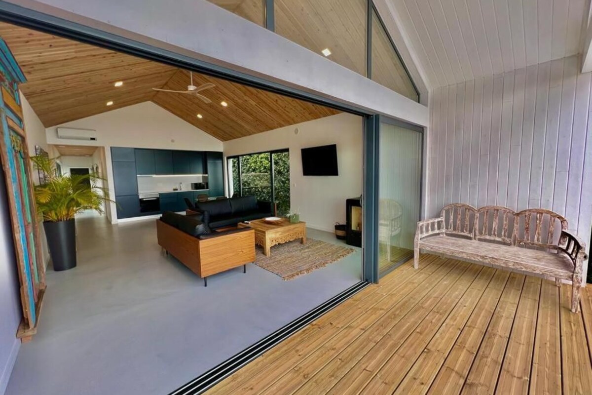 A modern living space with a wooden ceiling, a sofa, a coffee table, and a bench.