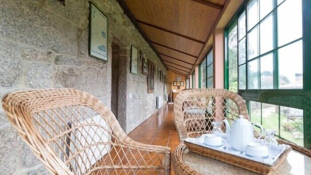A corridor with wicker chairs and a tray with white teapots and cups. - Casa da Urcela (Ponteareas)