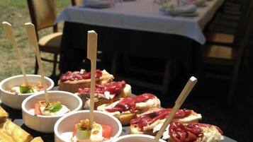 A table with food items and a view of a garden area.