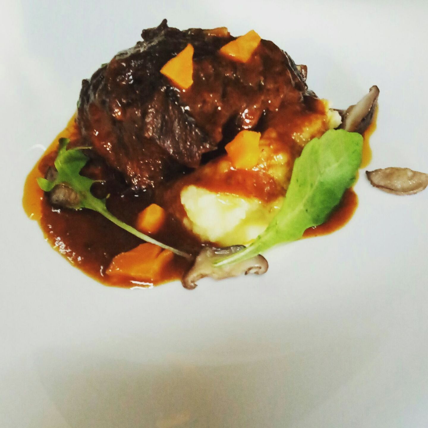 Plat de menjar amb carn, verdures i una salsa.