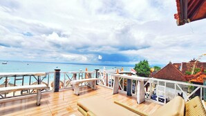 A wooden deck with lounge chairs and a view of the ocean. - The Beach Huts Lembongan (Lembongan Island)