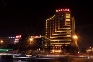 A multi-story hotel with illuminated signage and a modern architectural design. - Xiangyu Hotel (Shangqiu Municipal Government High-speed Railway Station) (Shangqiu)
