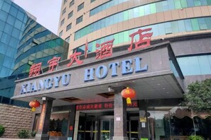 A hotel entrance with signage in a foreign language, a covered entrance area, and a modern building facade. - Xiangyu Hotel (Shangqiu Municipal Government High-speed Railway Station) (Shangqiu)