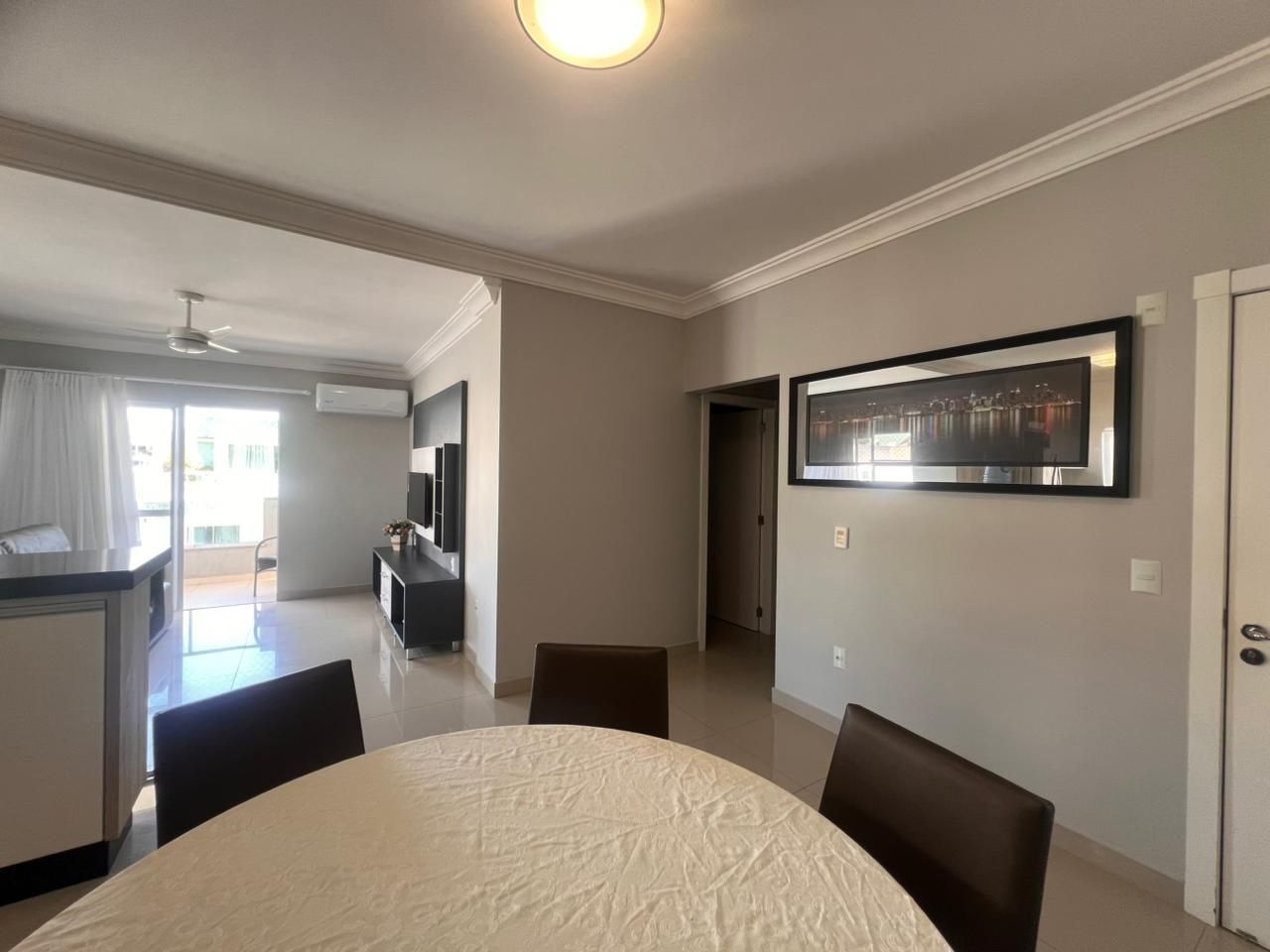 Un salon moderne comprenant un coin repas, une cuisine et un balcon.