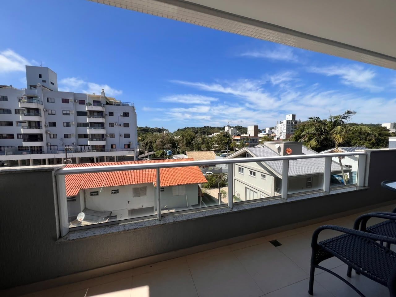 A balcony with a view of buildings and a clear sky.
