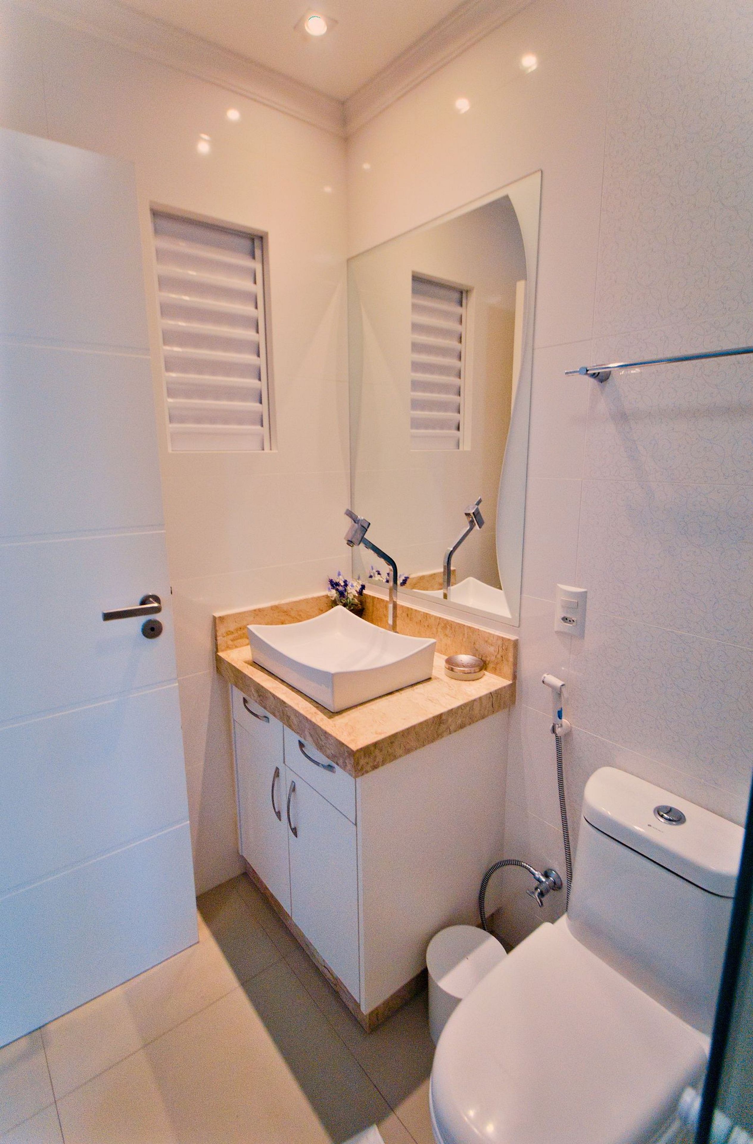 Een moderne badkamer met een witte wastafel, een dubbele wastafelbladafwerking en een toilet.