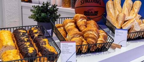 Une vitrine de boulangerie présentant divers produits de boulangerie, notamment du pain et des pâtisseries.