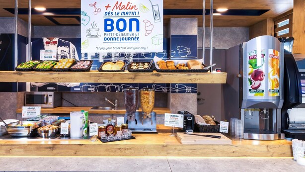 A breakfast buffet with various food items and a coffee machine. - Ibis Budget Libourne (Libourne)