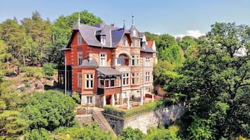 Perched on a hillside, this hotel offers a scenic view of lush greenery and trees from its balcony with a balustrade.