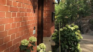 A brick building with a covered entrance, outdoor lighting, and potted plants. - Hotel Villa Viktoria Luise (Blankenburg)