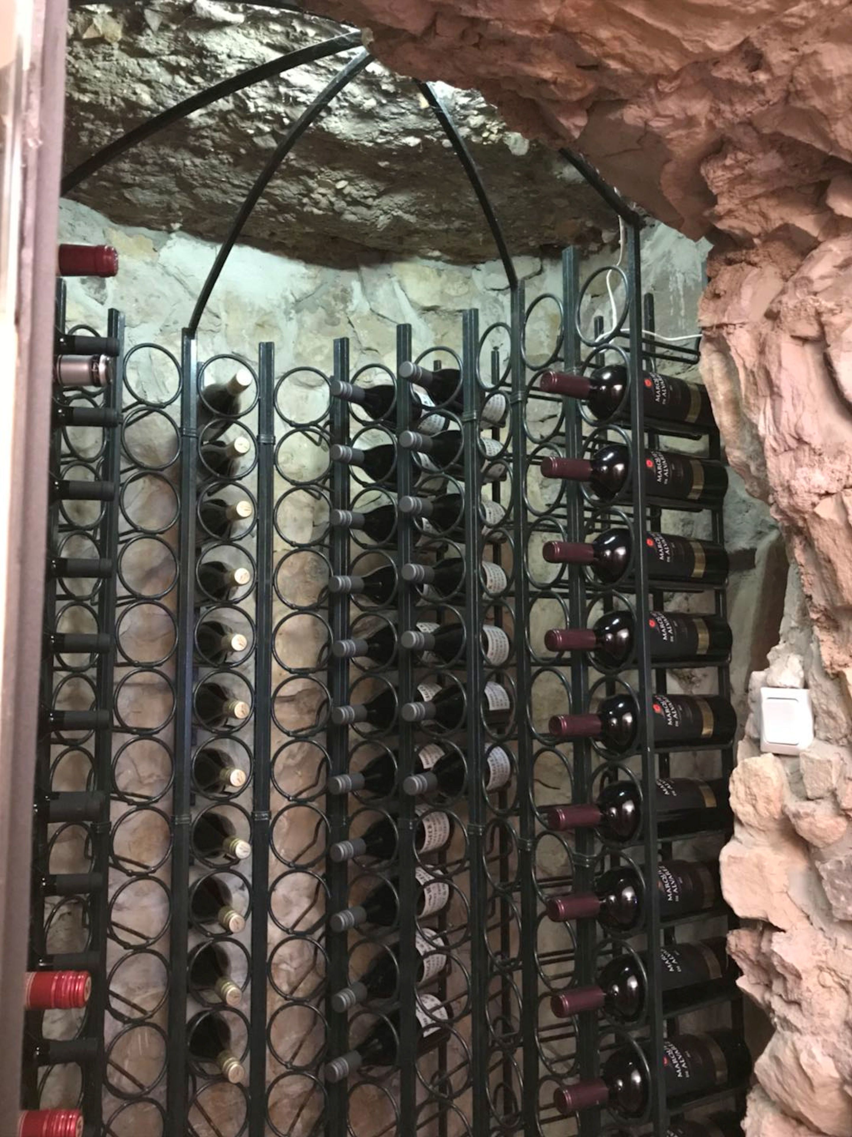 A wine rack with multiple bottles in a cellar.