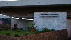 A modern building with a stone facade, a water feature, and a mural.