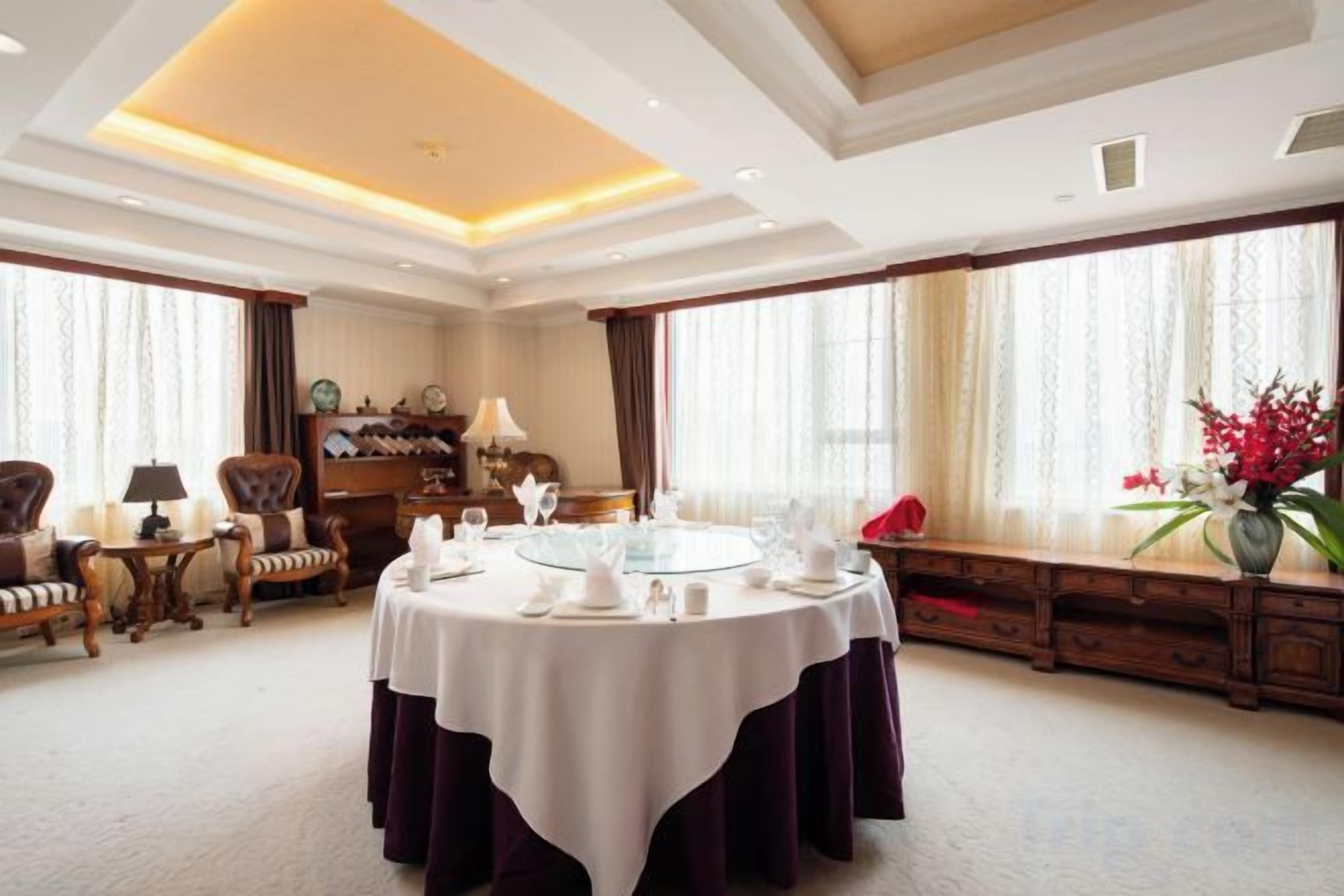 A dining room with a round table, chairs, and a chandelier.