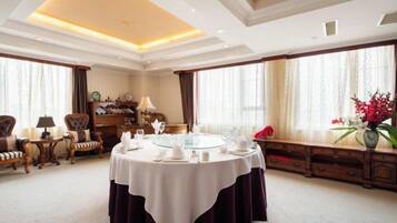 A dining room with a round table, chairs, and a chandelier.