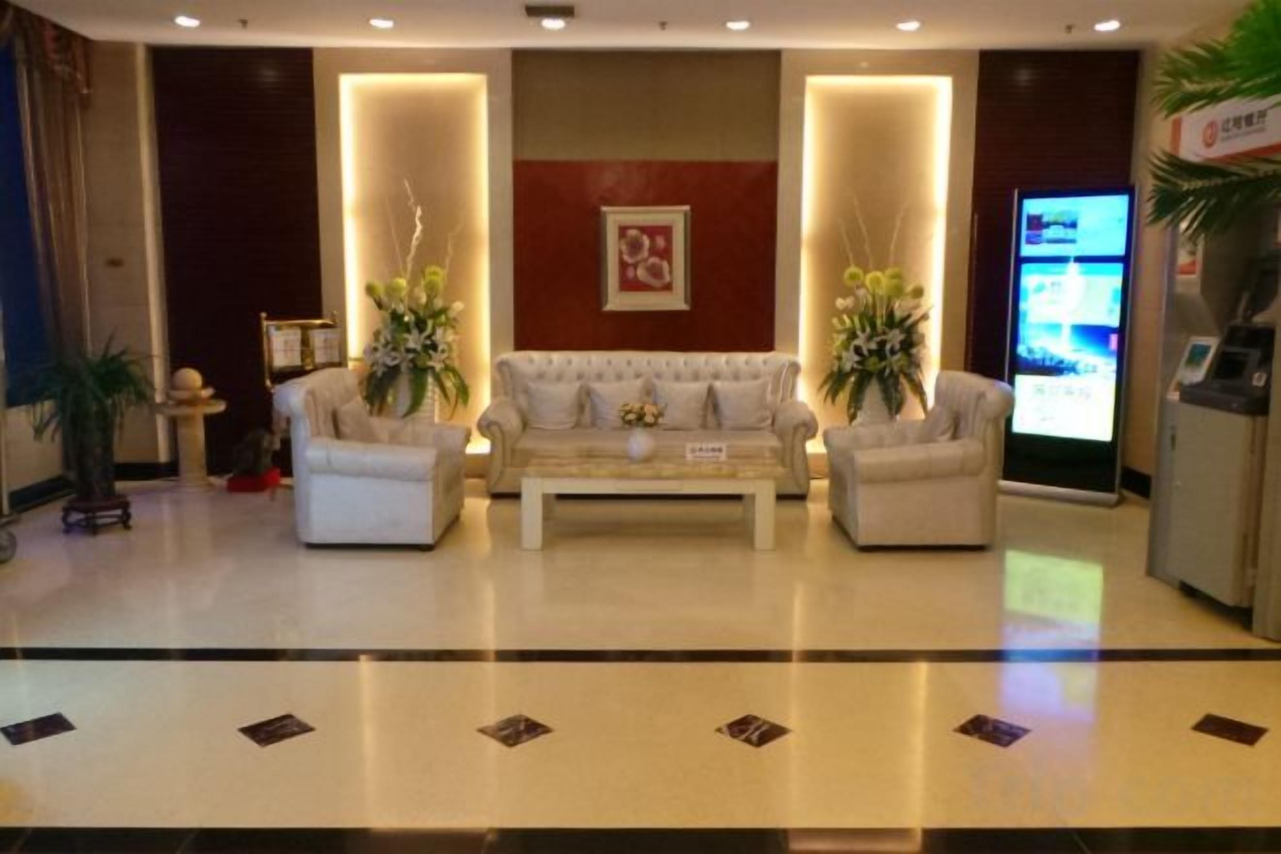 A lobby with a reception desk, two sofas, and a coffee table.