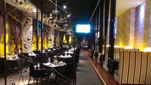 A restaurant with a long, narrow layout, featuring tables and chairs arranged along a central walkway. - Grand View International Hotel (LIAOYANG)