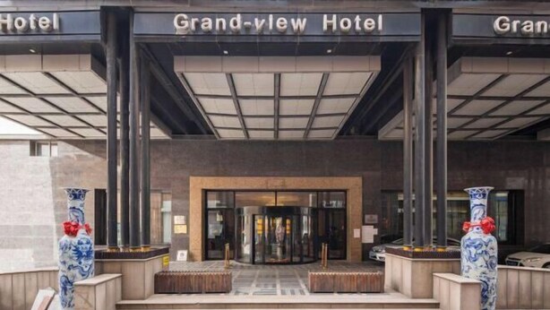 The Grandview Hotel entrance with a modern design, featuring a glass door and a set of stairs leading up to it. - Grand View International Hotel (LIAOYANG)