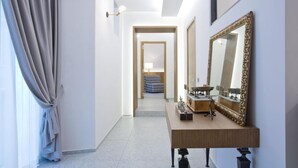 A hallway with a wooden desk, a large ornate mirror, and a patterned chair in the background. - Annunziata Guesthouse, Centro Storico (Naples)