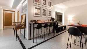 A modern kitchen with a bar area, a dining table, and a TV. - Annunziata Guesthouse, Centro Storico (Naples)