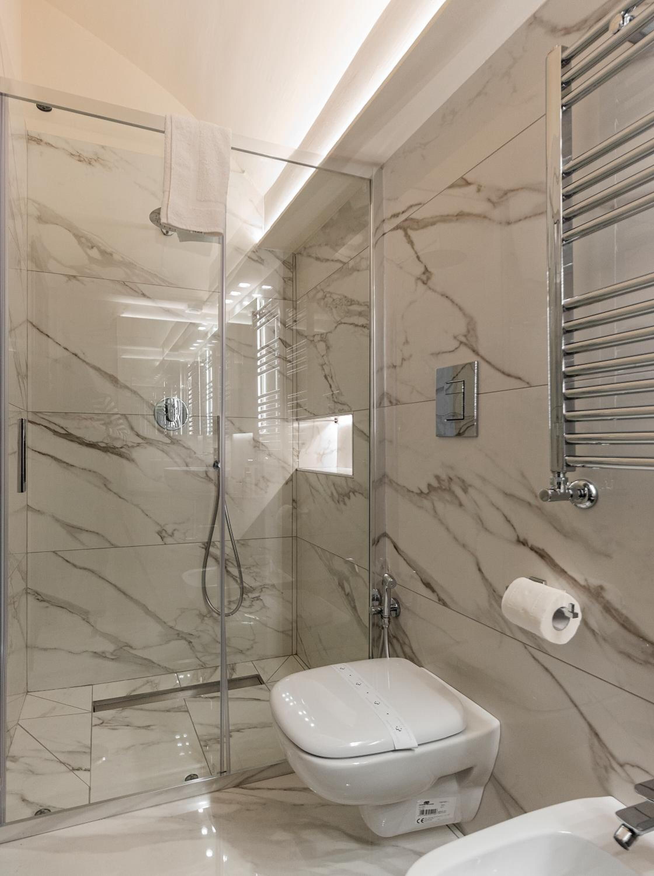 Une salle de bain moderne avec une douche à parois de verre, des toilettes et un lavabo.